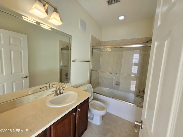 bathroom featuring tile patterned flooring, vanity, toilet, combined bath / shower with glass door, and visible vents