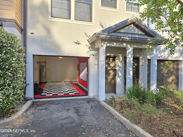 property entrance featuring stucco siding and electric water heater