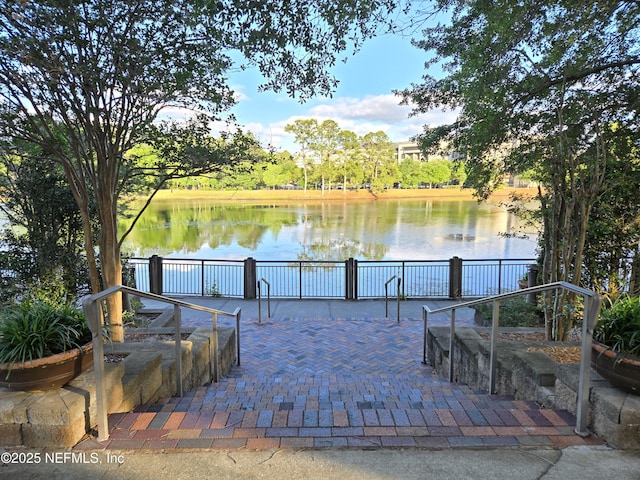 surrounding community featuring a water view and a patio