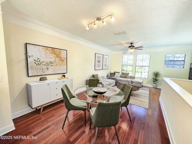 dining area featuring crown molding, ceiling fan, baseboards, dark wood-type flooring, and visible vents