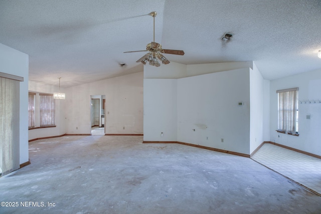 1742 Tiffany Pines Cir E, Jacksonville, FL 32225 - unfurnished living room featuring concrete floors, ceiling fan with notable chandelier, vaulted ceiling, and a healthy amount of sunlight