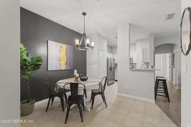 8601 Beach Blvd Unit 323, Jacksonville, FL 32216 - dining room featuring baseboards, light tile patterned flooring, a notable chandelier, and visible vents