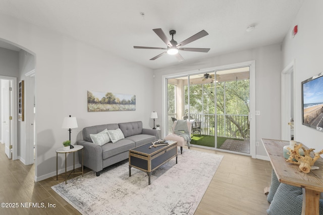 8601 Beach Blvd Unit 323, Jacksonville, FL 32216 - living area with baseboards, arched walkways, a ceiling fan, and wood finished floors