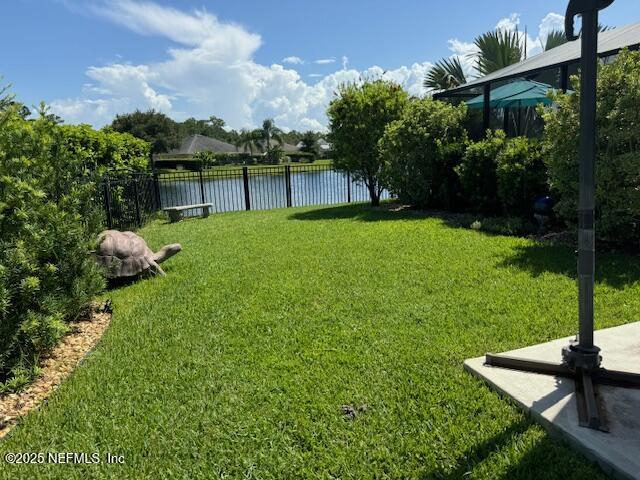 view of yard with a water view and fence