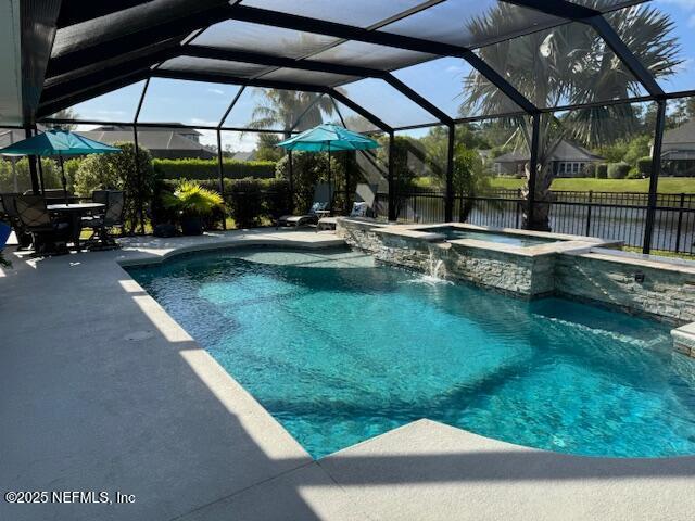 view of swimming pool with a patio area, a lanai, and a pool with connected hot tub