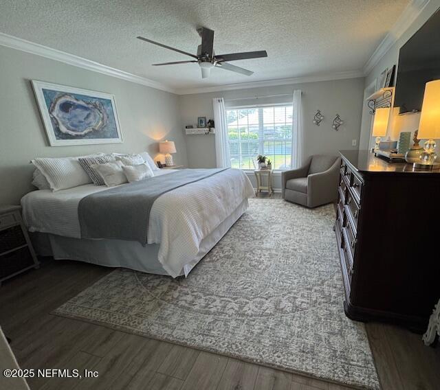 bedroom featuring ornamental molding, a textured ceiling, and wood finished floors