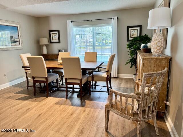 dining space featuring baseboards and light wood-style flooring