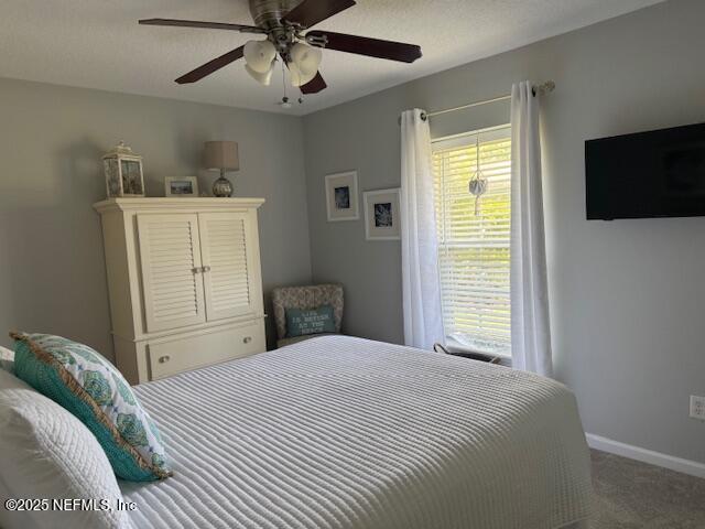 bedroom featuring baseboards, a ceiling fan, and carpet