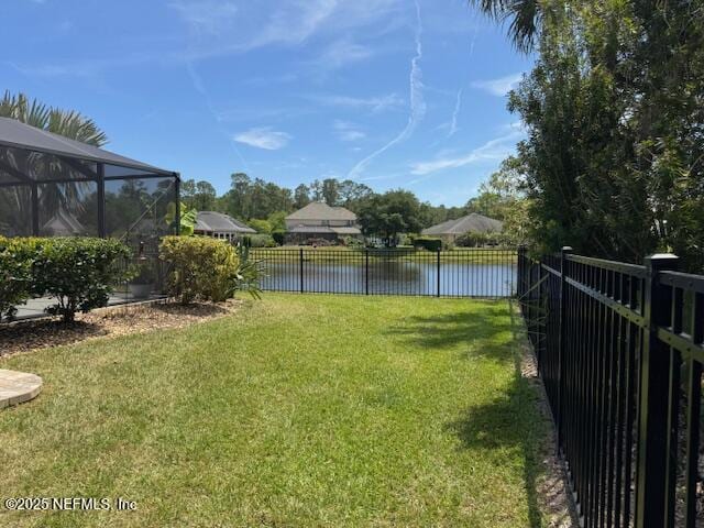 view of yard featuring a water view, a lanai, and a fenced backyard