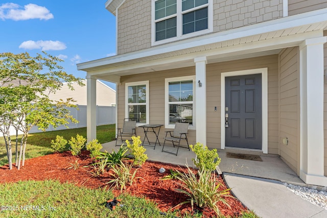 entrance to property featuring fence and covered porch