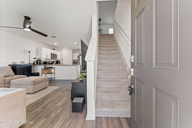 foyer entrance featuring recessed lighting, ceiling fan, wood finished floors, and stairway