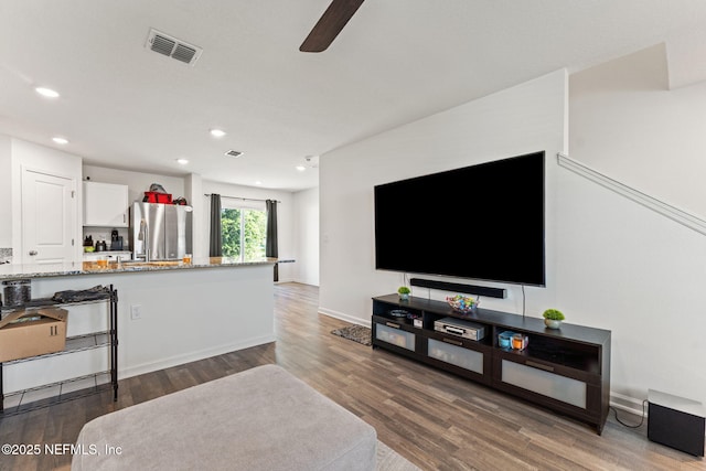 living area featuring visible vents, wood finished floors, baseboards, ceiling fan, and recessed lighting