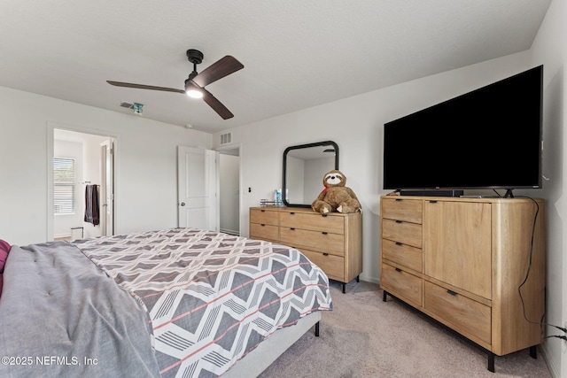 bedroom featuring visible vents, a ceiling fan, connected bathroom, and light colored carpet
