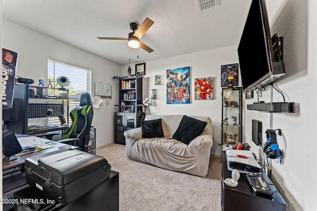 carpeted office space with a textured ceiling, ceiling fan, visible vents, and baseboards