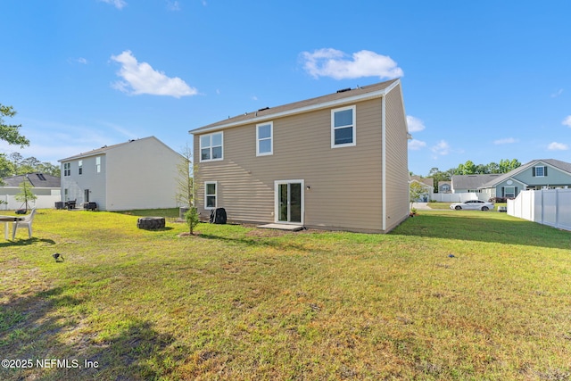 rear view of house featuring a lawn, fence, and a residential view