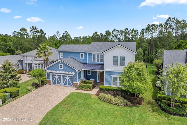 traditional home with an attached garage, board and batten siding, a front yard, decorative driveway, and a standing seam roof