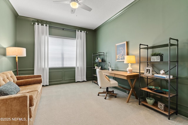carpeted office space featuring ornamental molding and ceiling fan