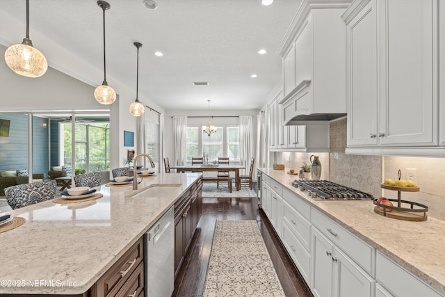 kitchen with white cabinetry, tasteful backsplash, a sink, dark wood finished floors, and stainless steel appliances