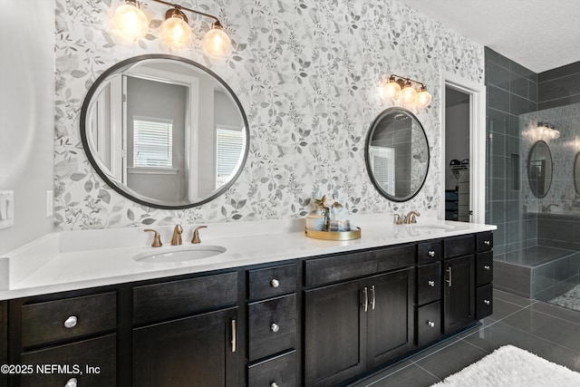 full bathroom featuring double vanity, a tile shower, a sink, and tile patterned flooring