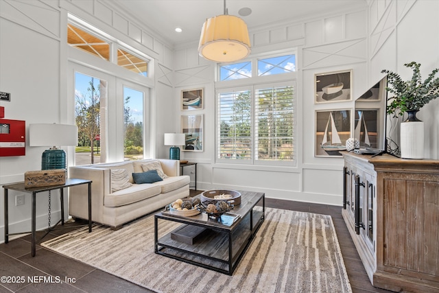 living area featuring a healthy amount of sunlight, a decorative wall, and dark wood finished floors