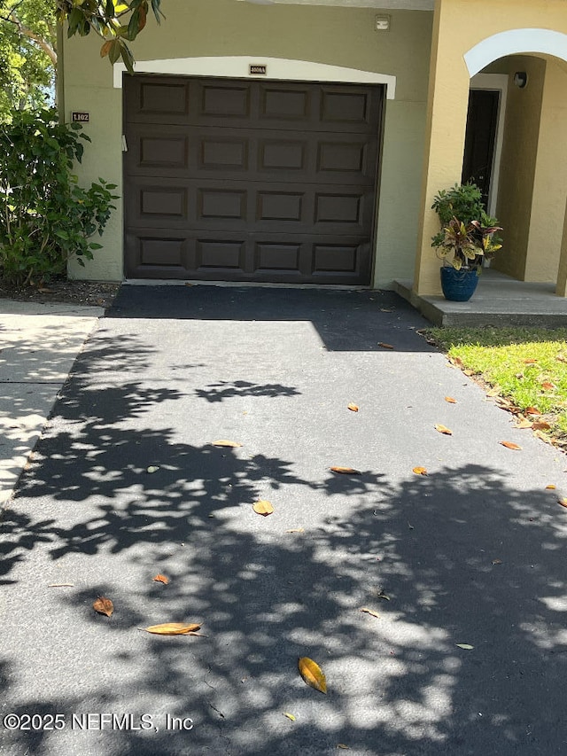 garage featuring asphalt driveway