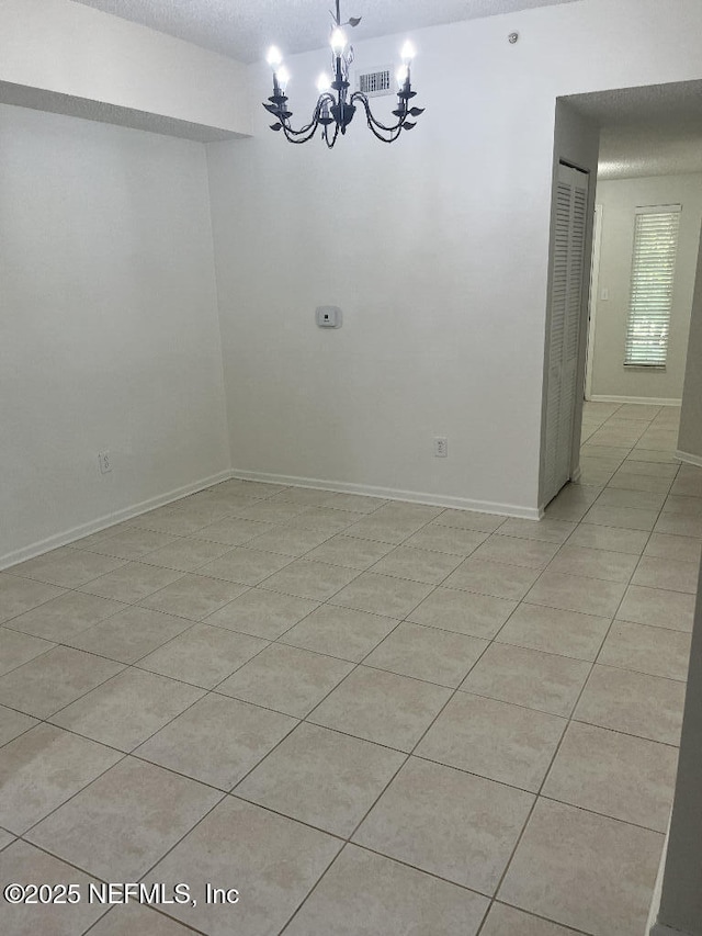 unfurnished dining area with a chandelier, light tile patterned flooring, and baseboards