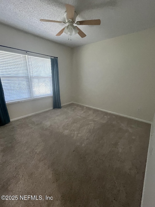 unfurnished room featuring carpet floors, a ceiling fan, and baseboards