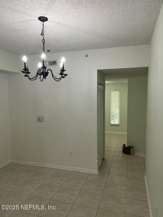 4000 Grande Vista Blvd Unit 15-102, Saint Augustine, FL 32084 - unfurnished room with a textured ceiling, light tile patterned floors, a chandelier, and baseboards
