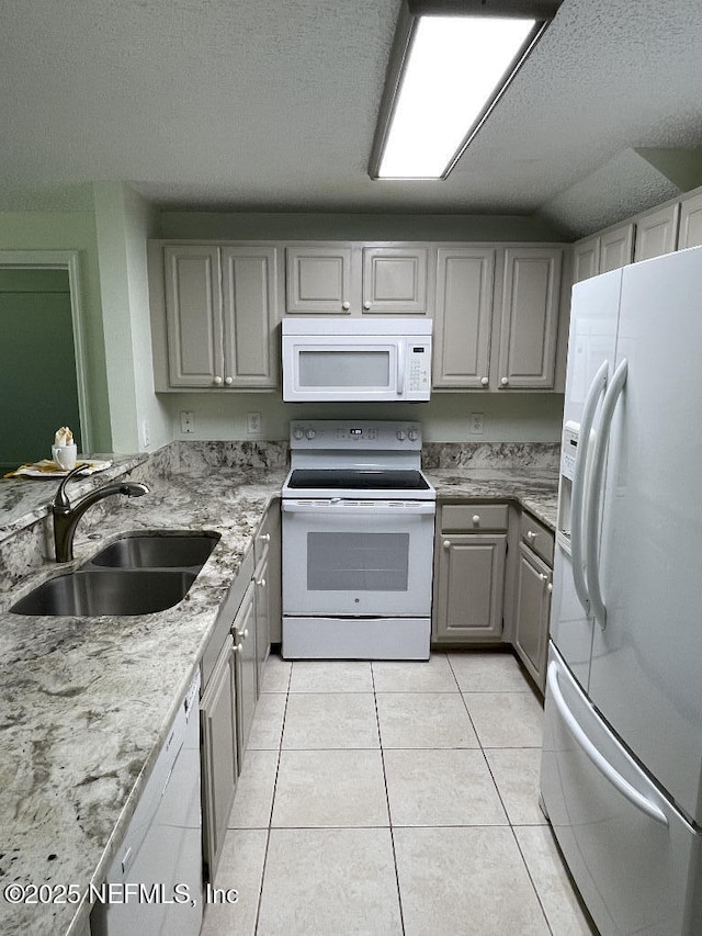 4000 Grande Vista Blvd Unit 15-102, Saint Augustine, FL 32084 - kitchen with white appliances, a sink, gray cabinetry, light tile patterned flooring, and a textured ceiling