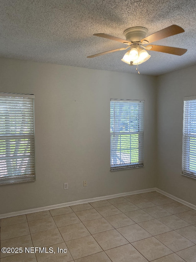 4000 Grande Vista Blvd Unit 15-102, Saint Augustine, FL 32084 - empty room featuring light tile patterned floors, a textured ceiling, a ceiling fan, and baseboards