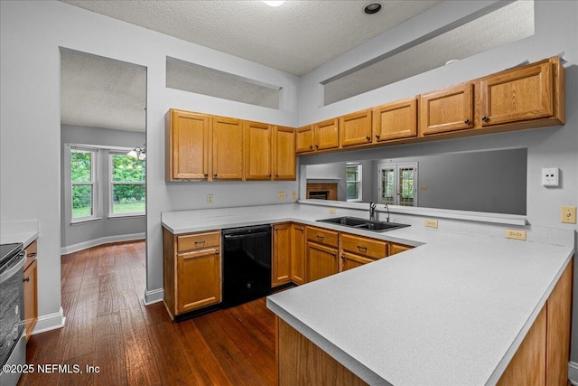 1800 Norway Dr, Fleming Island, FL 32003 - kitchen with dishwasher, a sink, a peninsula, a textured ceiling, and dark wood finished floors