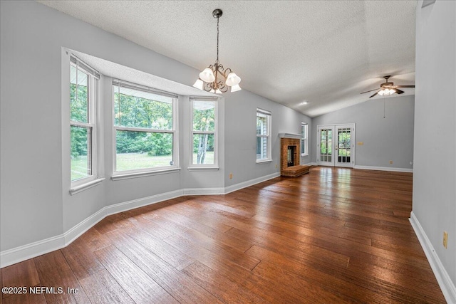 1800 Norway Dr, Fleming Island, FL 32003 - unfurnished living room with hardwood / wood-style floors, a textured ceiling, a chandelier, lofted ceiling, and a brick fireplace