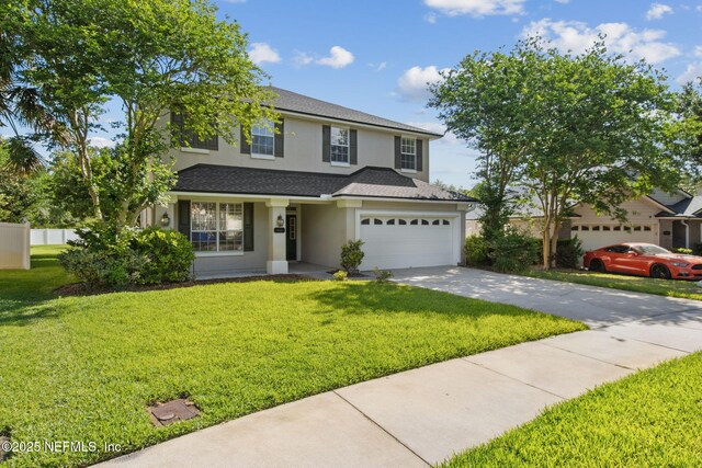 traditional home featuring concrete driveway, roof with shingles, a front yard, and stucco siding