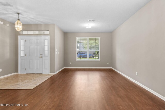 foyer entrance with baseboards and wood finished floors