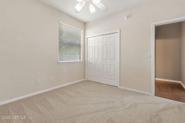 unfurnished bedroom with a ceiling fan, baseboards, carpet, and a closet