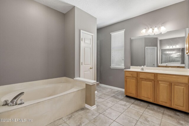 bathroom with vanity, baseboards, tile patterned flooring, and a garden tub