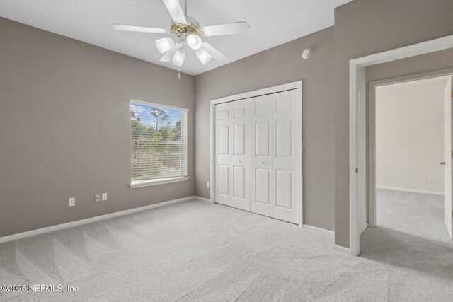 unfurnished bedroom featuring carpet flooring, baseboards, and a closet