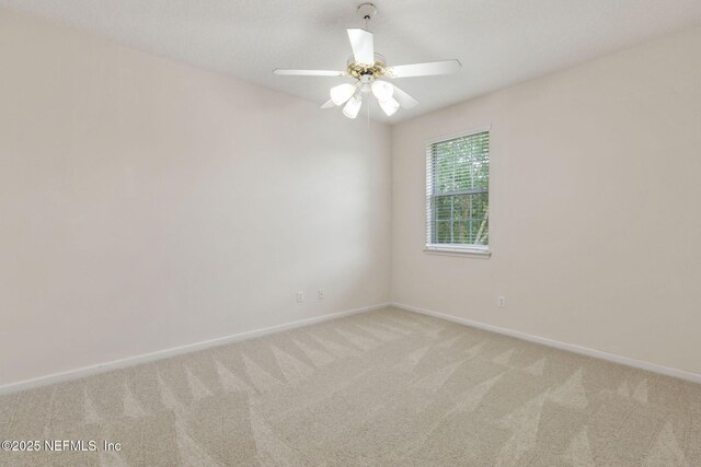 unfurnished room featuring baseboards, a ceiling fan, and light carpet