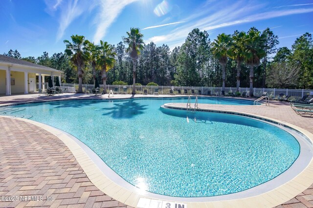 pool with fence and a patio