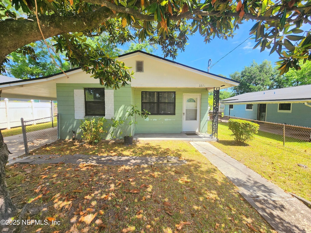 2271 W 10th St, Jacksonville, FL 32209 - bungalow-style house with a front lawn and fence