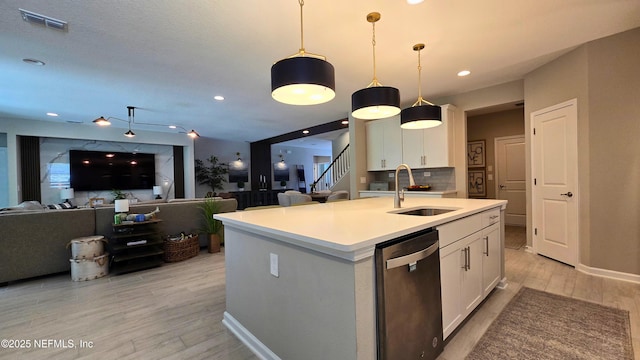 kitchen with a sink, dishwasher, white cabinetry, light wood-type flooring, and visible vents