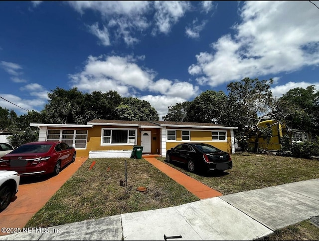 view of front of property featuring stucco siding and a front yard