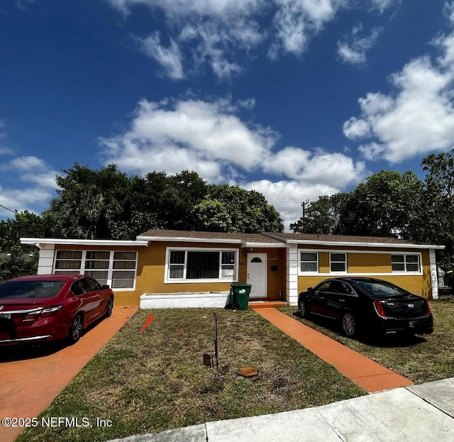 view of front of home featuring a front yard and stucco siding