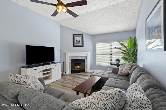32238 Settlers Ridge Dr, Bryceville, FL 32009 - living room with a ceiling fan, light wood finished floors, a textured ceiling, a high end fireplace, and lofted ceiling