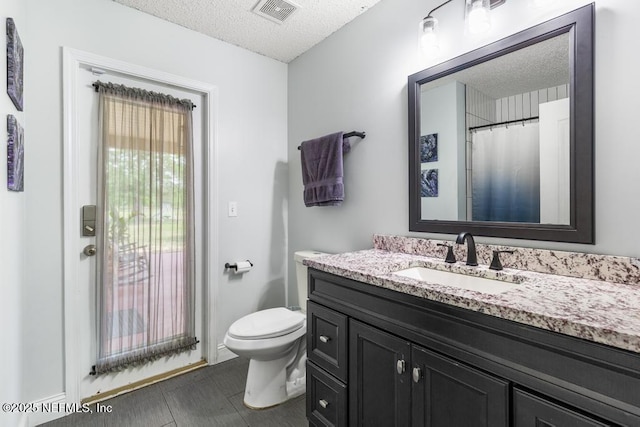32238 Settlers Ridge Dr, Bryceville, FL 32009 - bathroom featuring a textured ceiling, vanity, toilet, and baseboards