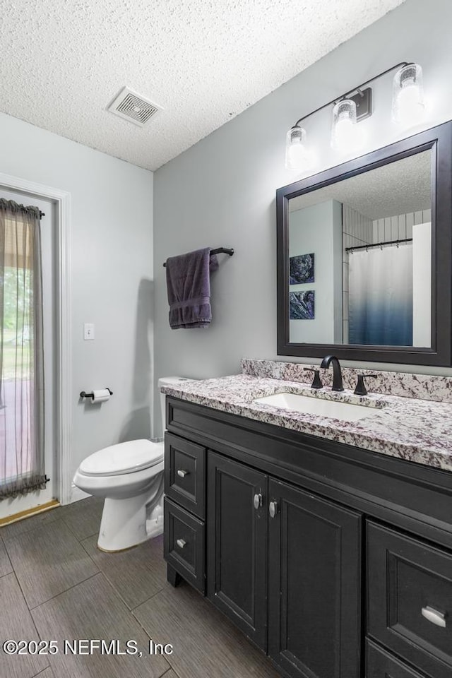 32238 Settlers Ridge Dr, Bryceville, FL 32009 - full bath with vanity, a textured ceiling, toilet, and wood finished floors