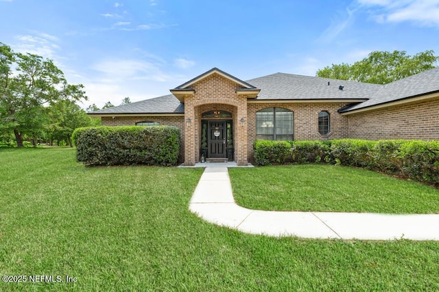 32238 Settlers Ridge Dr, Bryceville, FL 32009 - view of front of house with a front lawn, roof with shingles, and brick siding