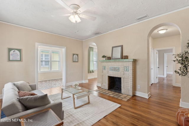 4534 College St, Jacksonville, FL 32205 - living room with arched walkways, healthy amount of natural light, wood finished floors, a fireplace, and crown molding