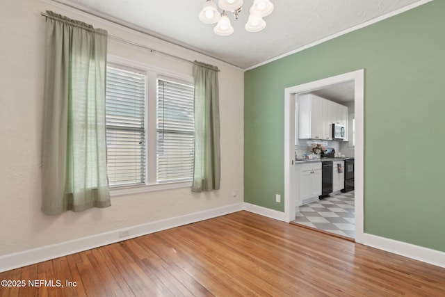 4534 College St, Jacksonville, FL 32205 - empty room with a chandelier, baseboards, ornamental molding, and light wood finished floors