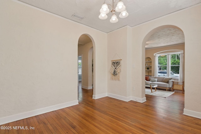 4534 College St, Jacksonville, FL 32205 - spare room featuring hardwood / wood-style flooring, baseboards, ornamental molding, a chandelier, and arched walkways